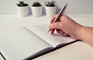 A stock photo of someone starting to make plans using a notebook