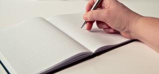A stock photo of someone starting to make plans using a notebook
