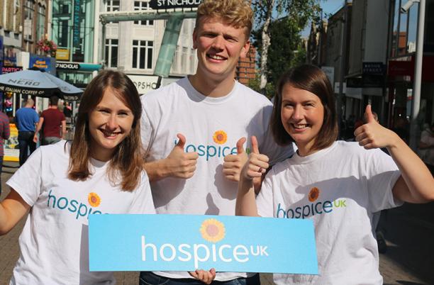3 Hospice UK staff members in Sutton High Street with their thumbs up