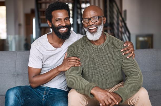Portrait of a happy young man relaxing and spending time with his father at home