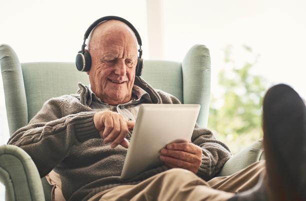 Older man watching film in tablet