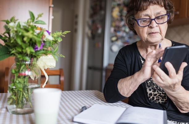 Older woman using smartphone with glasses on