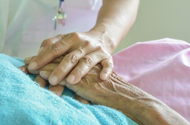 close up of holding hands on a bed
