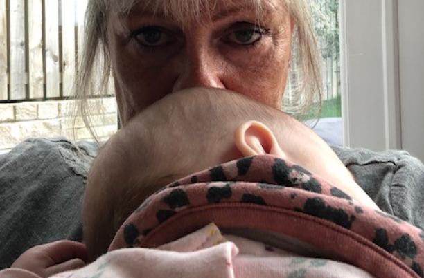 a woman with blonde hair kisses a baby's head