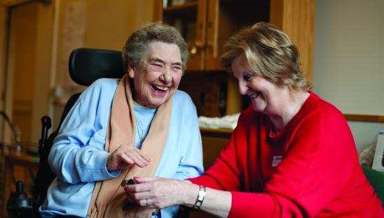 Older woman with in wheelchair with nurse