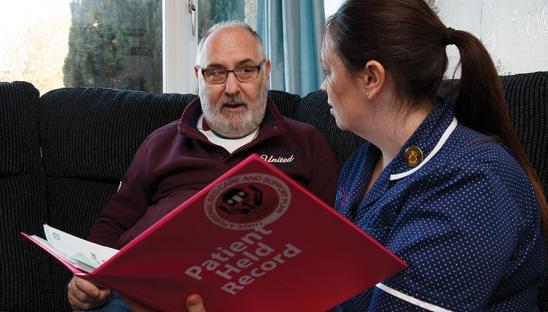 Man discussing and looking at health record with nurse