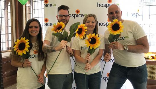 James with the team awaiting runners at the 2019 London Marathon holding sunflowers