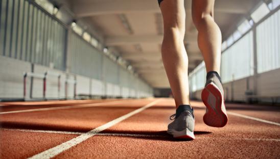 A stock photo of someone warming up on an indoor athletics track