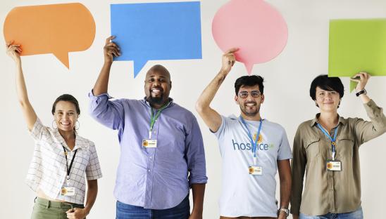 Four people holding up speech bubbles